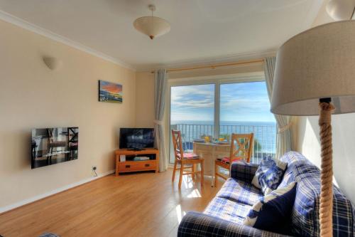 a living room with a couch and a table with a television at 6 Bay View Court in Lyme Regis