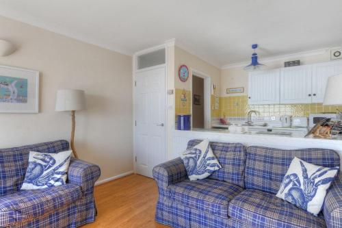 a living room with two couches and a kitchen at 6 Bay View Court in Lyme Regis