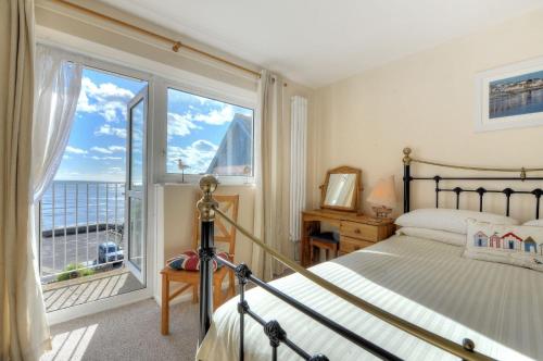 a bedroom with a bed and a large window at 6 Bay View Court in Lyme Regis