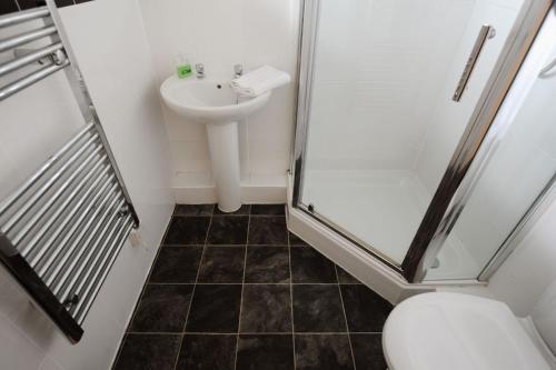 a bathroom with a shower and a toilet and a sink at 6 Bay View Court in Lyme Regis