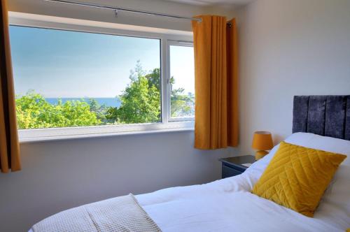 a bedroom with a bed and a large window at Lottys Lookout in Lyme Regis