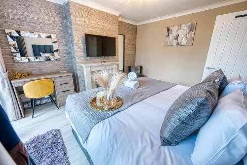a bedroom with a bed with a table and a television at Stunning 5 Bed House - Sleeps 9, Central Solihull, NEC, JLR, HS2, Resorts World, Airport Business and Leisure Stays, in Solihull