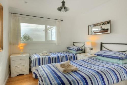 a bedroom with two beds and a window at Dolphins Leap in Charmouth