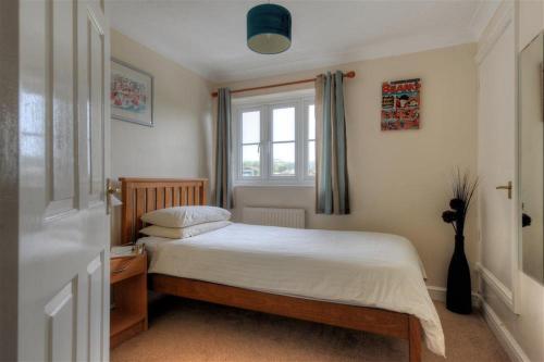 a small bedroom with a bed and a window at 4 Riverside Cottages in Charmouth