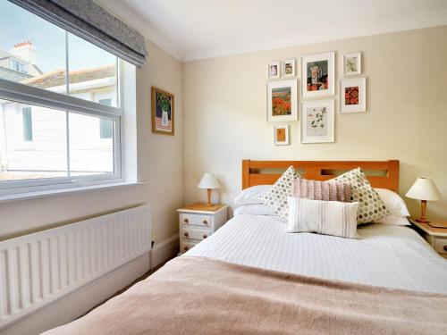 a bedroom with a bed and a window at 2 Cobb View in Lyme Regis