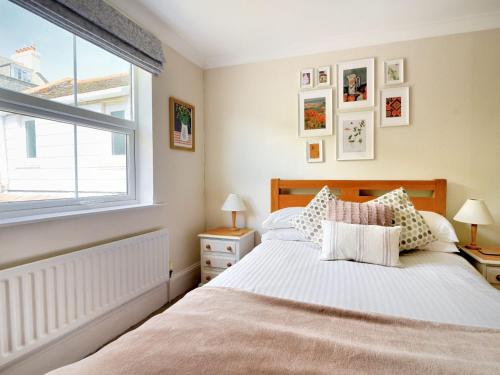 un dormitorio con una cama y una ventana en 2 Cobb View, en Lyme Regis