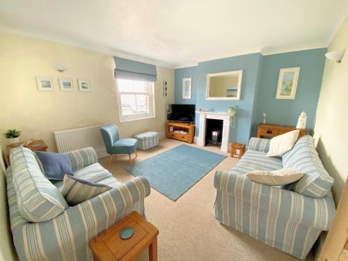 a living room with two couches and a fireplace at 2 Cobb View in Lyme Regis