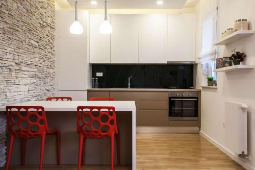 a kitchen with red chairs and a white counter top at Apartment I Love Zagreb, free private parking in Zagreb