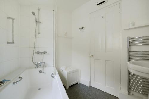 ein Badezimmer mit Badewanne, Waschbecken und Dusche in der Unterkunft Monmouth Cottage in Lyme Regis