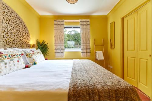 a bedroom with a large bed and a window at Xanadu: Stylish Family Home by the Pub and Beach in Beadnell