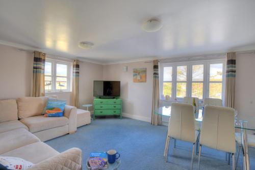 a living room with a couch and a table at 9 Maritime House in West Bay