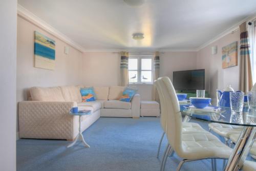 a living room with a couch and a table at 9 Maritime House in West Bay