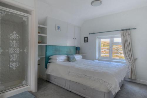 a bedroom with a bed and a window at Kelly Bray in Lyme Regis