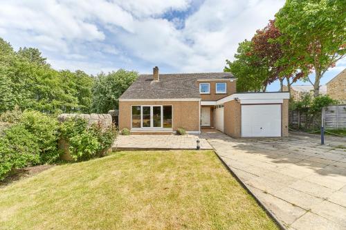 a brick house with a garage in a yard at Xanadu: Stylish Family Home by the Pub and Beach in Beadnell