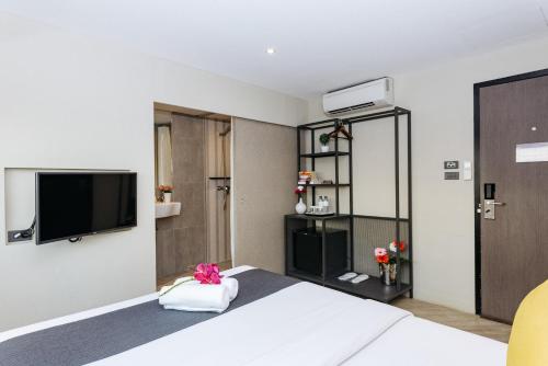 a hotel room with a bed and a flat screen tv at Lucky House Khaosan in Bangkok