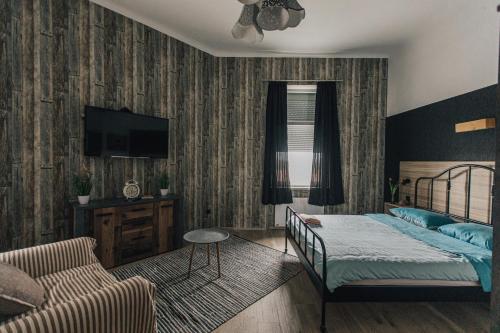 a bedroom with a bed and a couch and a tv at Palmers Apartments and Rooms in Zagreb