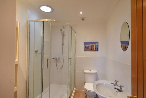 a bathroom with a shower and a toilet and a sink at Pendower in Charmouth