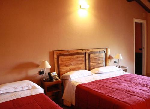 a bedroom with two beds and a telephone in it at Castello di Baccaresca in Branca