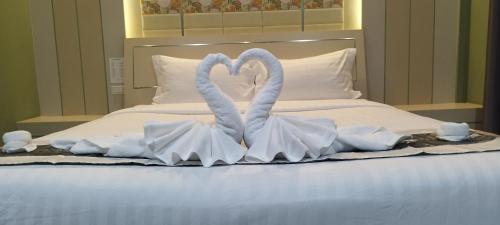 two swans making a heart shape on a bed at สวนหินวิลล่า รีสอร์ท in Ban Chot