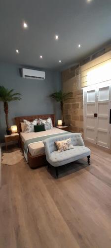 1 dormitorio con cama, sofá y ventana en Casal Annunzia Boutique B&B Accomodation en Tarxien