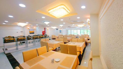 Khách Sạn Lạc Hồng Mỹ Tho - Lac Hong My Tho Hotel في مي ثو: غرفة طعام مع طاولات وكراسي وكاونتر