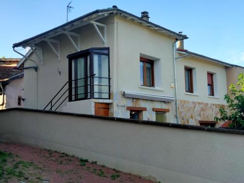 a white house with a balcony on top of a wall at Chambre d'hôtes Juline in Pouilly-les-Nonains