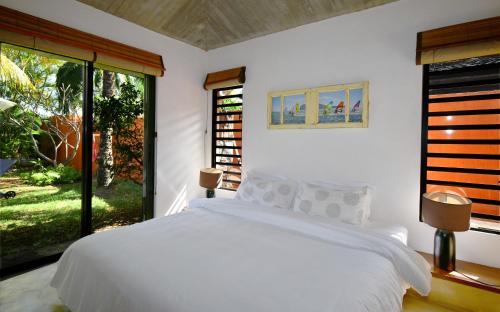 a bedroom with a white bed and a large window at Elegant Villa with pool and privacy Blue Bay in Blue Bay