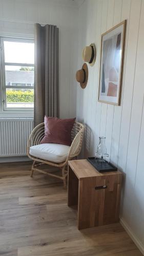 a living room with a chair and a couch and a window at Hørby Færgekro in Holbæk