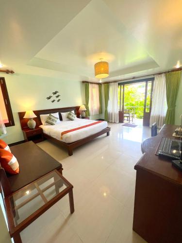 a bedroom with a bed and a desk in a room at PS Thana Resort in Choeng Mon Beach
