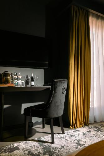 a chair sitting in front of a table with at Mert Boutique Hotel in Korçë