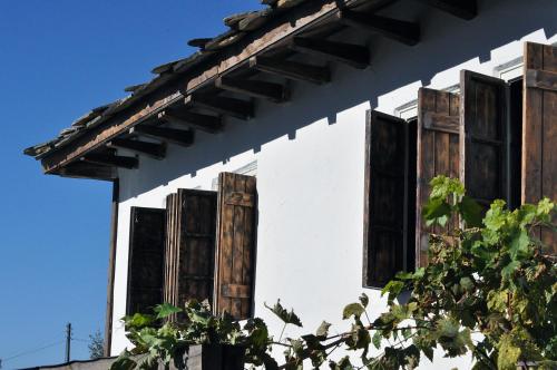 a white building with wooden shuttered windows on it at The Four Houses in Kostenkovtsi