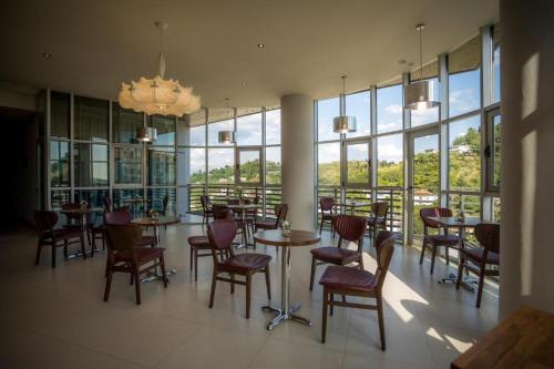 um restaurante com mesas e cadeiras e um lustre em Sky Hotel em Shkodër