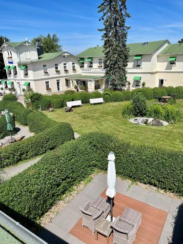 a patio with two chairs and an umbrella and a building at Panorama Hotel Lohme in Lohme