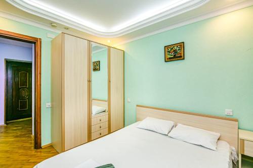 a bedroom with a white bed and a mirror at M Estate Targovi Sweet home in Baku