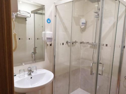a bathroom with a shower, sink, and toilet at Hostal Las Fuentes in Madrid