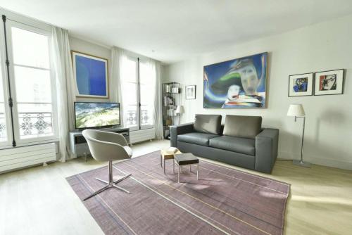 un salon avec un canapé et une chaise dans l'établissement Champagne, à Paris