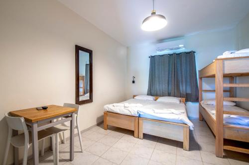 a bedroom with two bunk beds and a table and a desk at כפר הנופש קיבוץ גדות Kibbutz Gadot Galilean Resort in Gadot