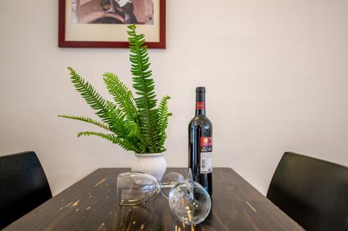 a bottle of wine and glasses on a table with a plant at כפר הנופש קיבוץ גדות Kibbutz Gadot Galilean Resort in Gadot