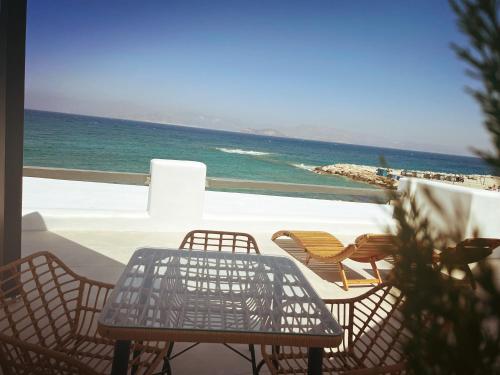 a table and chairs on a balcony overlooking the ocean at All Blue Suites in Ambelas