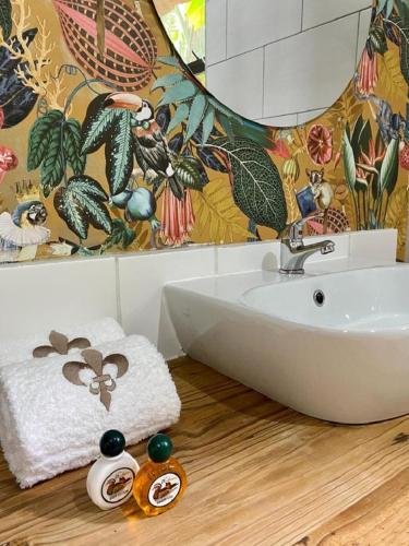 a bathroom with a white sink on a wooden floor at Ollivanders Estate in KwaNgendezi