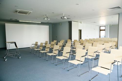 a room with rows of chairs and a white screen at Uva Nestum Wine & SPA in Gotse Delchev