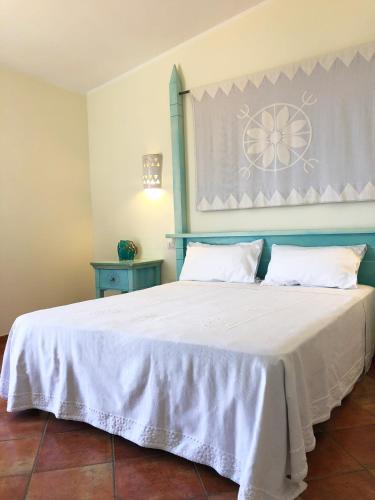 a bedroom with a large white bed with two pillows at LH Pedraladda Resort in Castelsardo