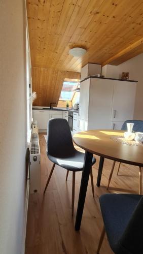 uma cozinha com mesa e cadeiras num quarto em Schloss Blick Bredendiek OG em Jever