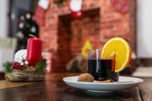 a plate with a glass of juice and an orange slice at Uva Nestum Wine & SPA in Gotse Delchev