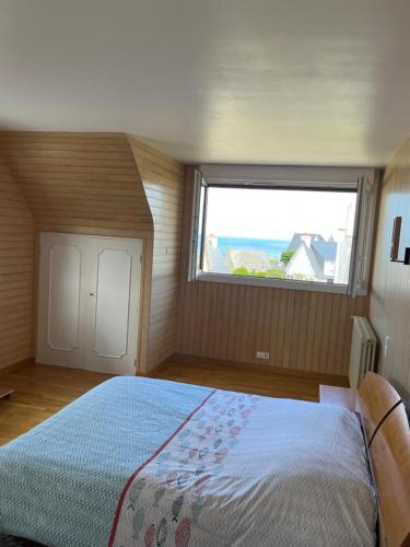 a bedroom with a large bed with a large window at The Cuban & SPA Privé in Perros-Guirec
