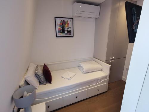 a white bench with pillows on it in a room at City Prime Apartments in London