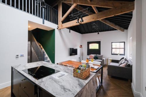 cocina y sala de estar con encimera de piedra en The Eden Warehouse - Green Apartment, sleeps 5 en Southport