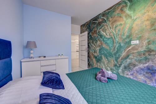 a bedroom with a bed with purple shoes on it at Apartamenty Silver 4 in Szczecin