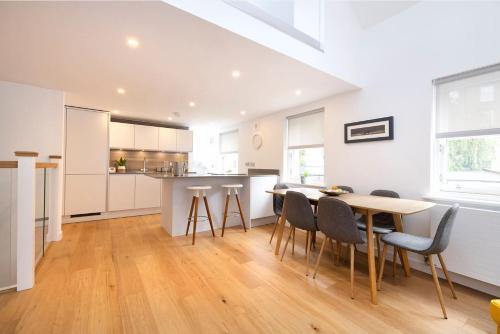 a kitchen and dining room with a table and chairs at Edinburgh Modern 3-Storey 3-Bedroom City Apartment in Edinburgh