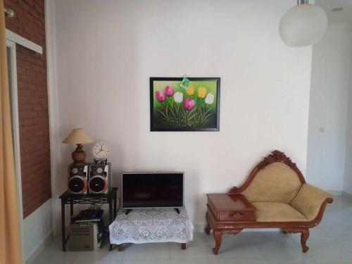 een woonkamer met een stoel en een tv bij Nanita Homestay in Talun